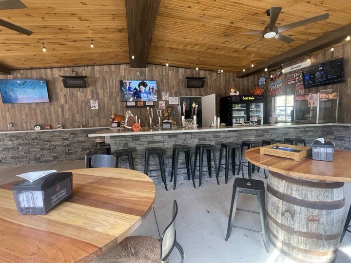 Inside the bar with barrel tables and stools