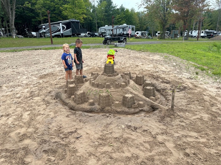 Kids building a sandcastle on the pond beach